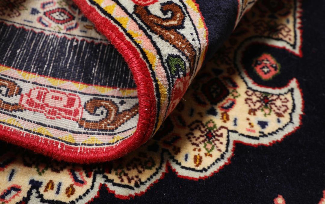 A hand-knotted Senneh rug from the Middle East featuring a vibrant red and black colour palette.