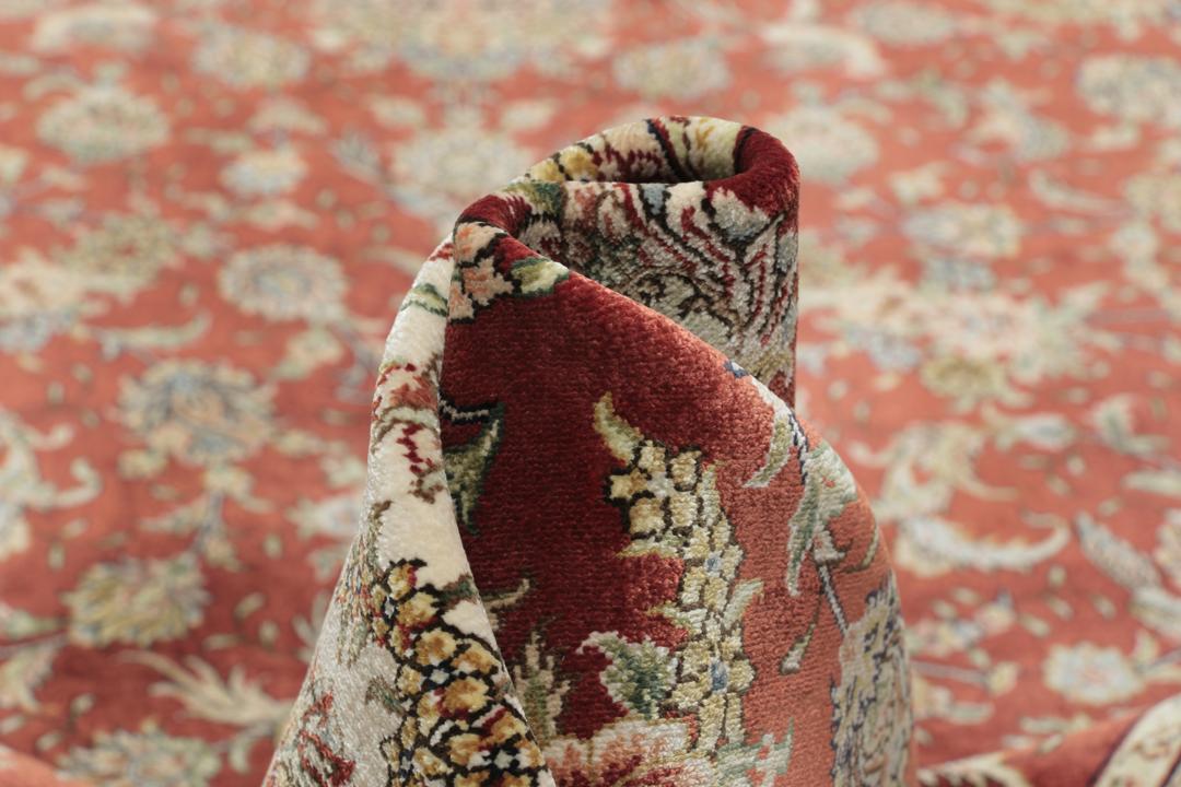 Et luksuriøst håndknyttet tæppe fra Kina med et dybt rødt felt og udsmykkede blomstermønstre.