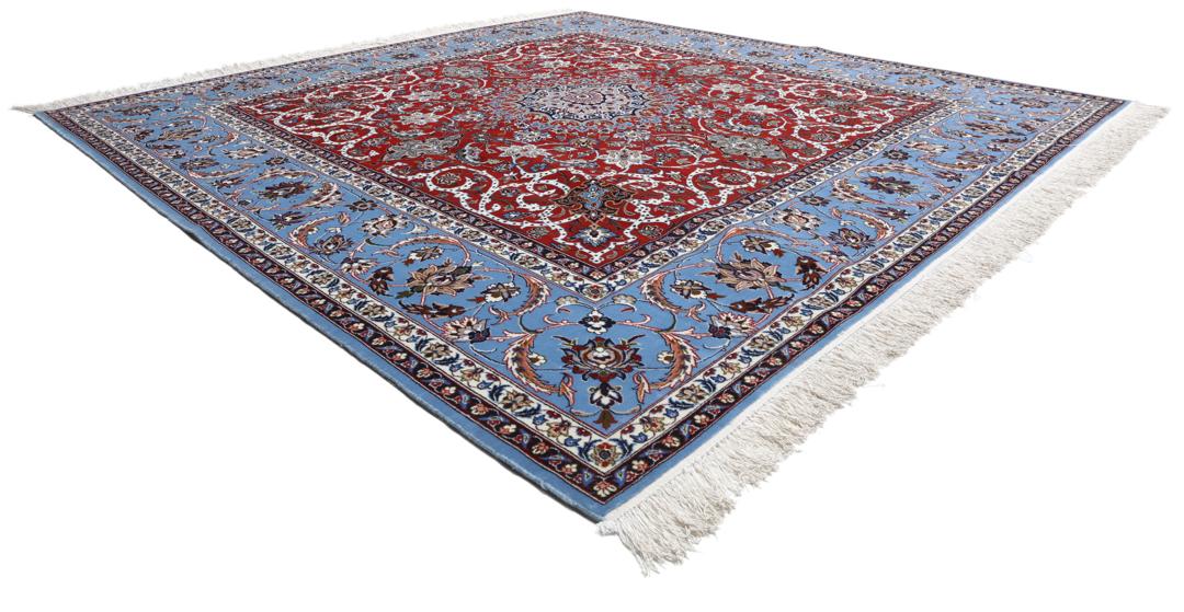 Een vierkant handgeknoopt Isfahan-tapijt uit het Midden-Oosten met een rood centraal medaillon en blauwe randen.
