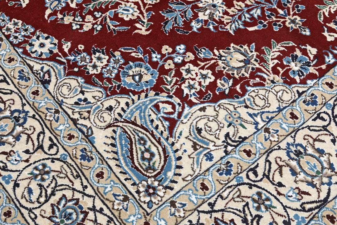 Nain rug from the Middle East featuring a central floral medallion in dark-red and blue