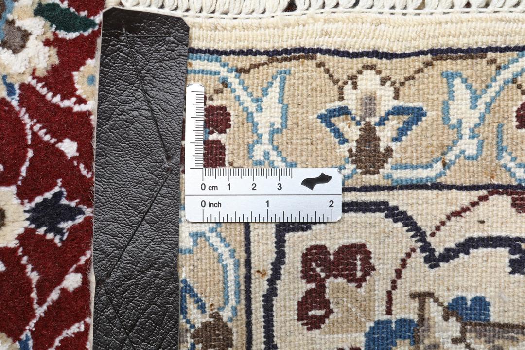 Nain rug from the Middle East featuring a central floral medallion in dark-red and blue