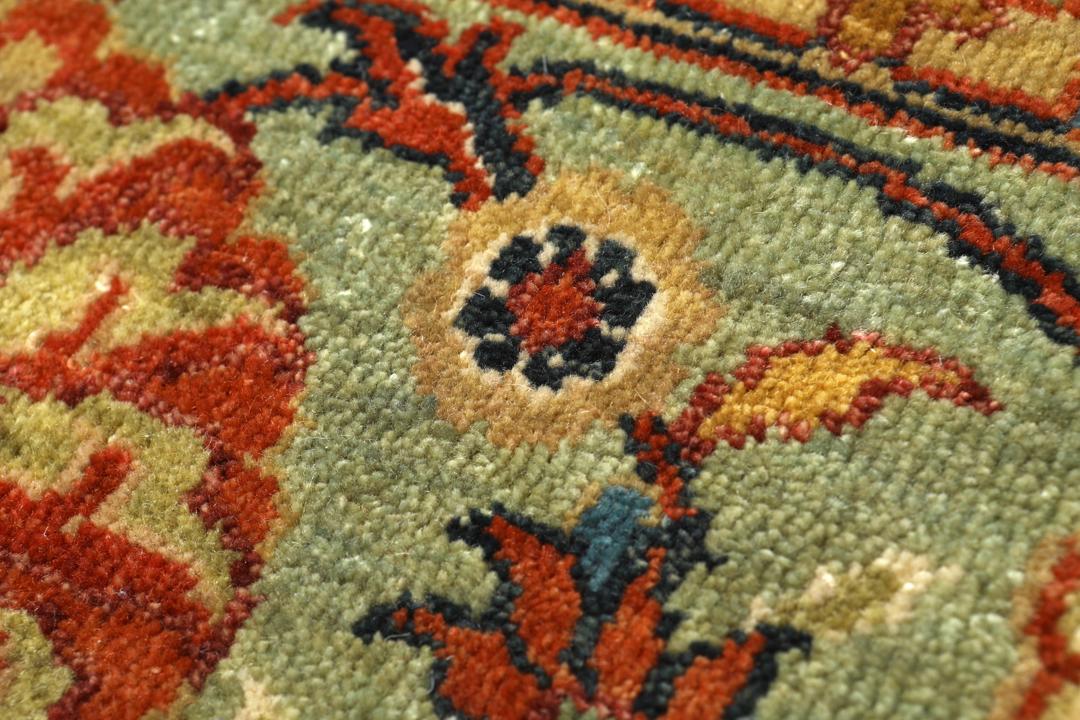 Ręcznie wiązany dywan Farahan z Pakistanu z beżowym tłem i motywami kwiatowymi w odcieniach zieleni i czerwieni.