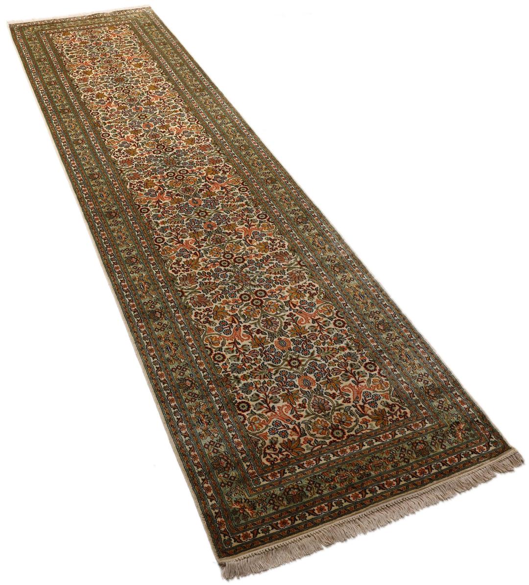 En lang, elegant Kashmir-silkelløber fra Indien med indviklede blomstermotiver i beige, grønne og bløde røde nuancer.