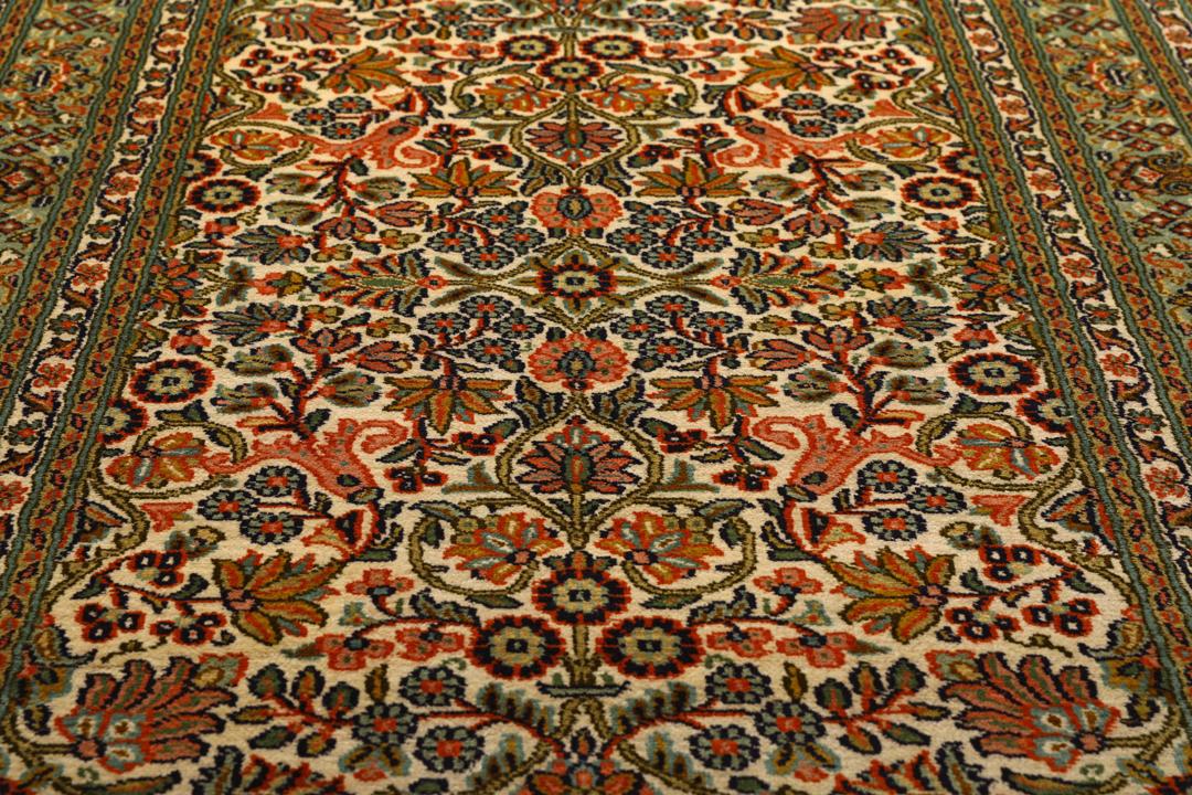 En lang, elegant Kashmir-silkelløber fra Indien med indviklede blomstermotiver i beige, grønne og bløde røde nuancer.