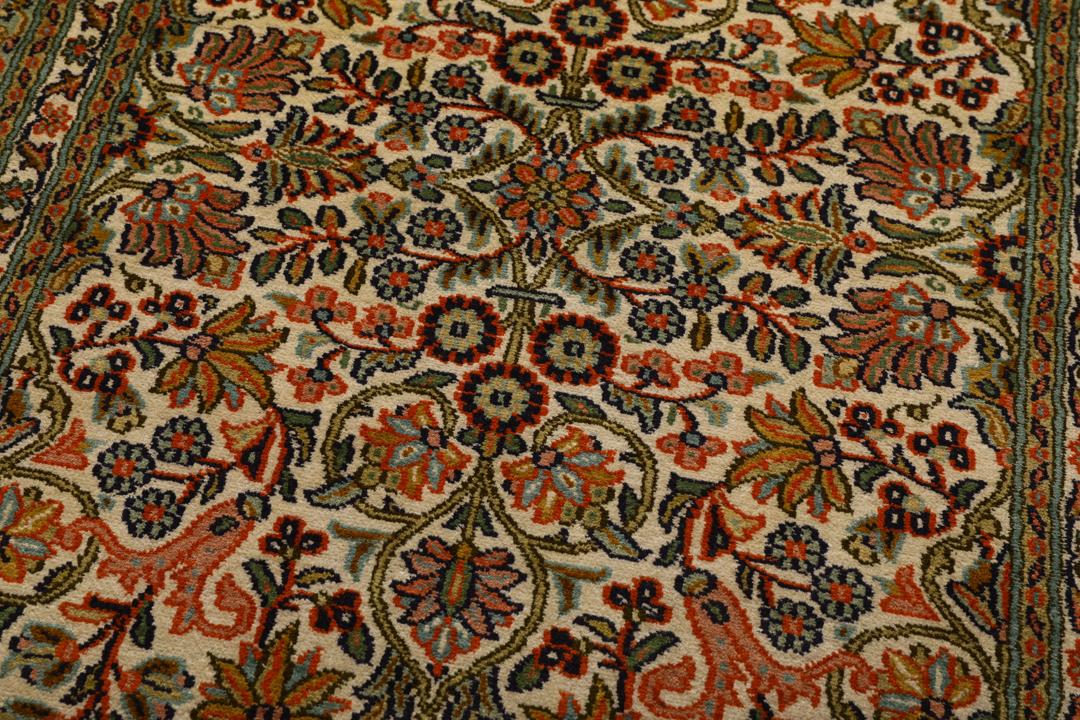 En lang, elegant Kashmir-silkelløber fra Indien med indviklede blomstermotiver i beige, grønne og bløde røde nuancer.
