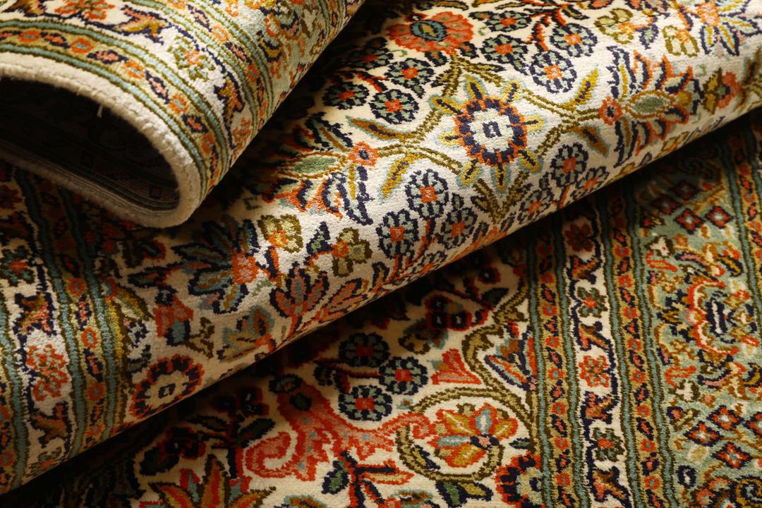 En lang, elegant Kashmir-silkelløber fra Indien med indviklede blomstermotiver i beige, grønne og bløde røde nuancer.