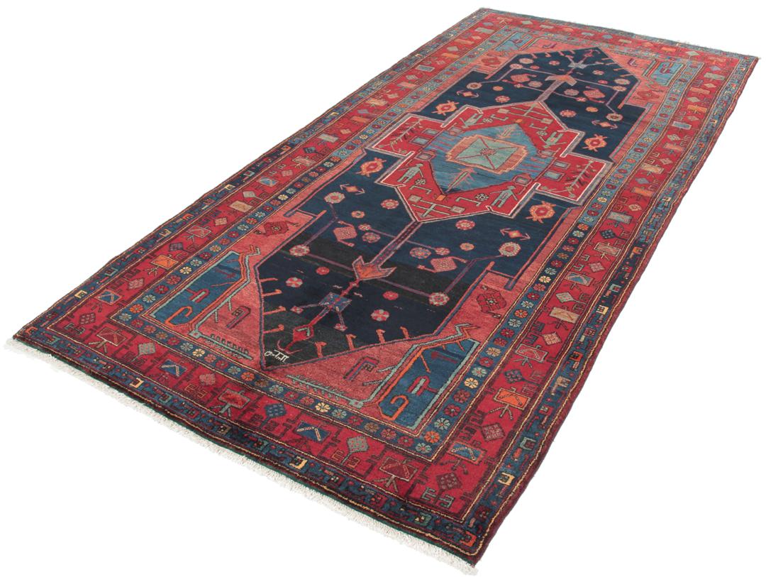 Een handgeknoopt Zanjan-tapijt uit het Midden-Oosten met een donkerblauw en rood geometrisch ontwerp.