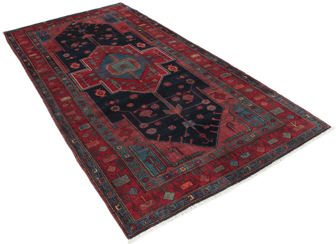 Een handgeknoopt Zanjan-tapijt uit het Midden-Oosten met een donkerblauw en rood geometrisch ontwerp.