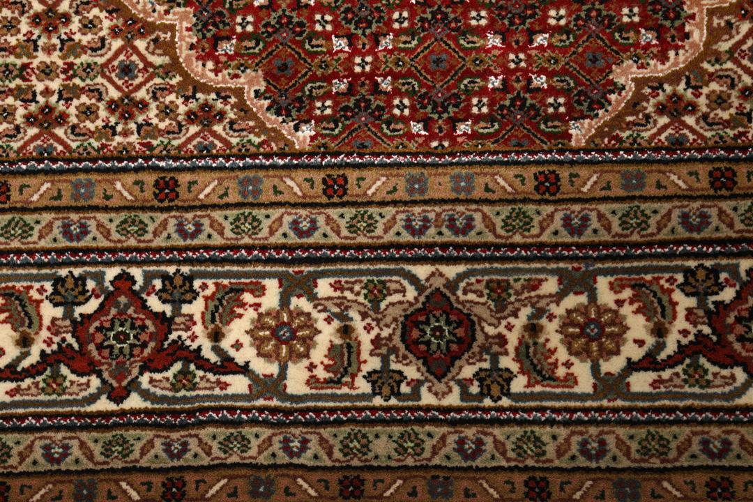 Czerwony ręcznie wiązany dywan Tabriz z centralnym medalionem i ozdobnymi obramowaniami.