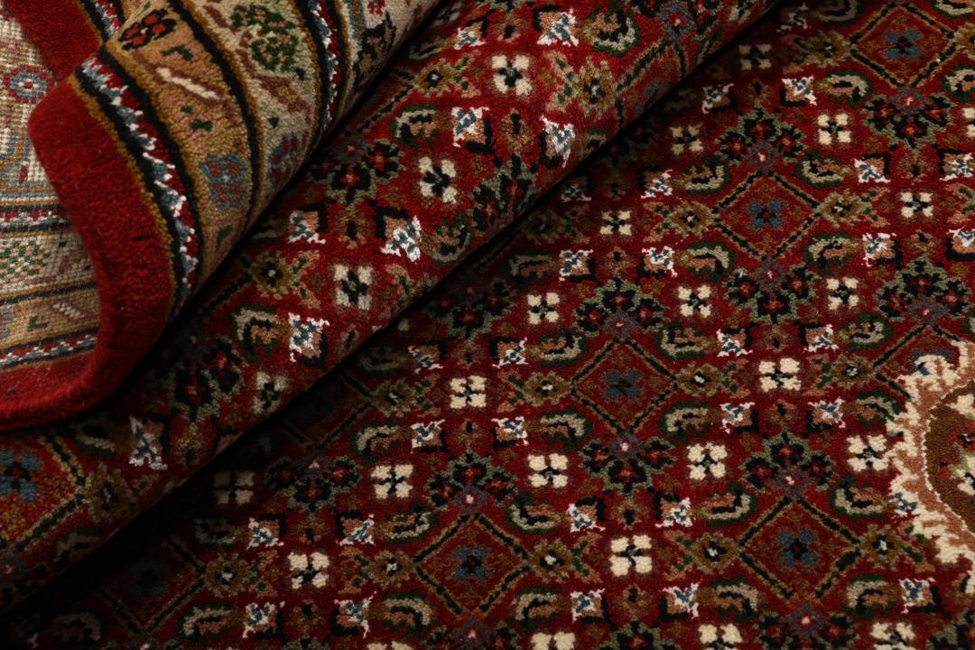 Czerwony ręcznie wiązany dywan Tabriz z centralnym medalionem i ozdobnymi obramowaniami.