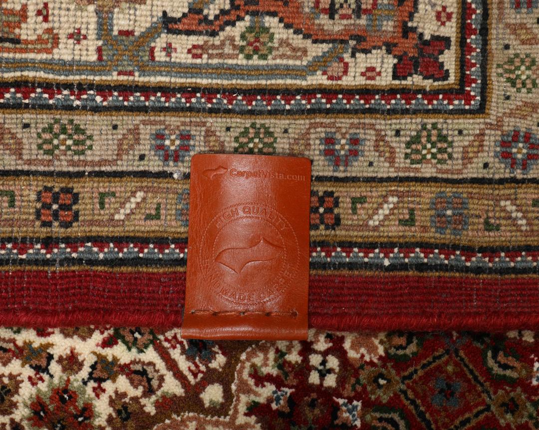 Czerwony ręcznie wiązany dywan Tabriz z centralnym medalionem i ozdobnymi obramowaniami.
