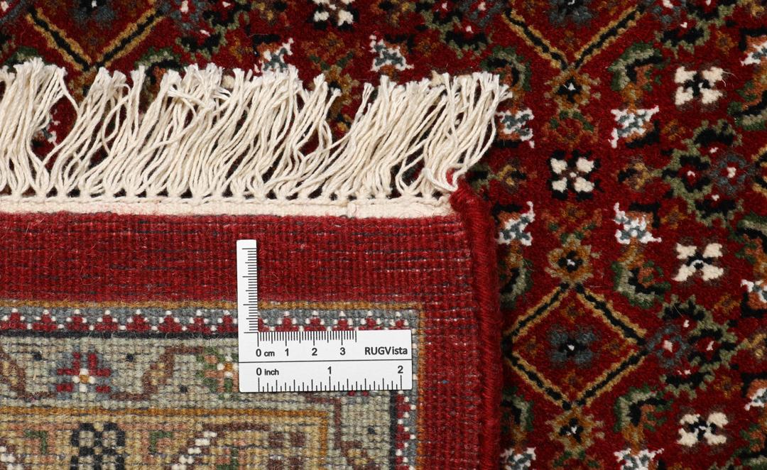 Ręcznie wiązany indyjski dywan Tabriz z dużym centralnym medalionem w odcieniach ciemnej czerwieni i beżu.
