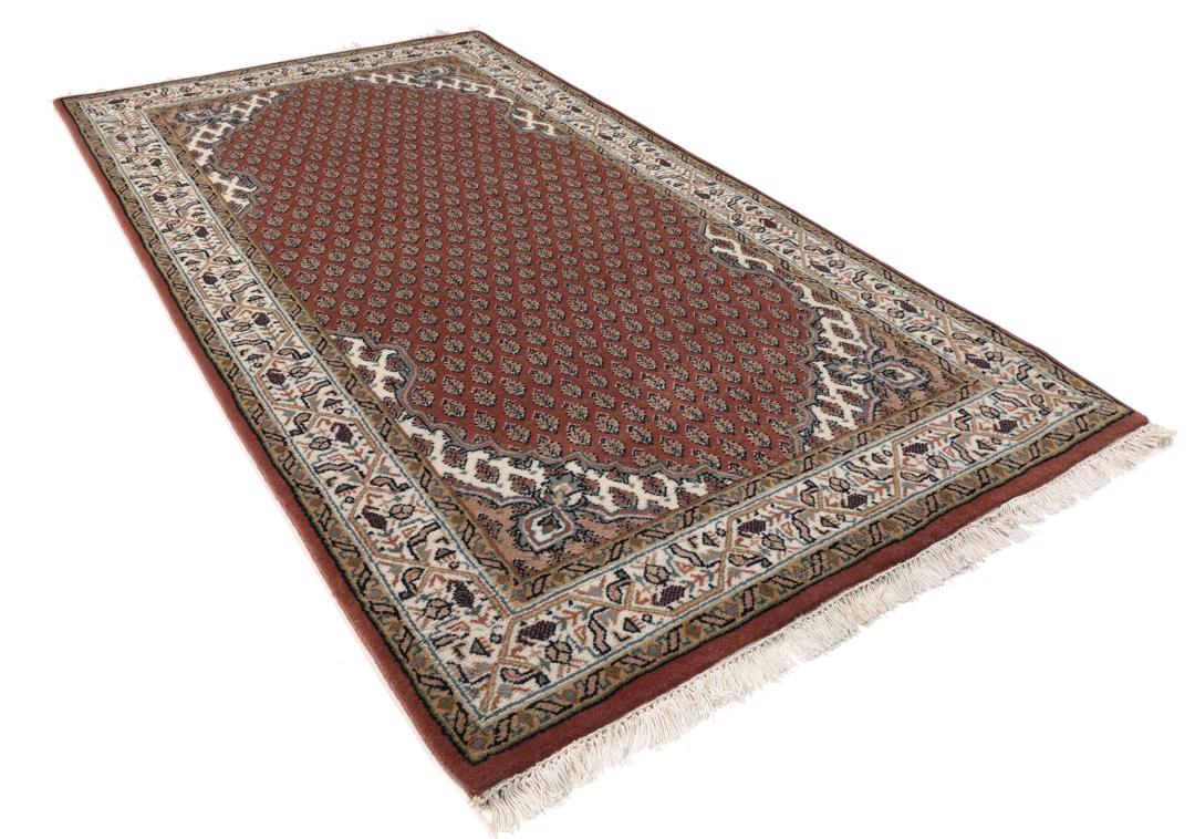 Een handgeknoopt Mir Indo tapijt uit India in donkerrood met een herhalend geometrisch patroon.