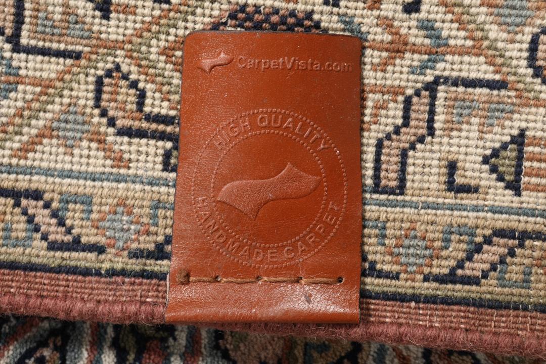Een handgeknoopt Mir Indo tapijt uit India in donkerrood met een herhalend geometrisch patroon.