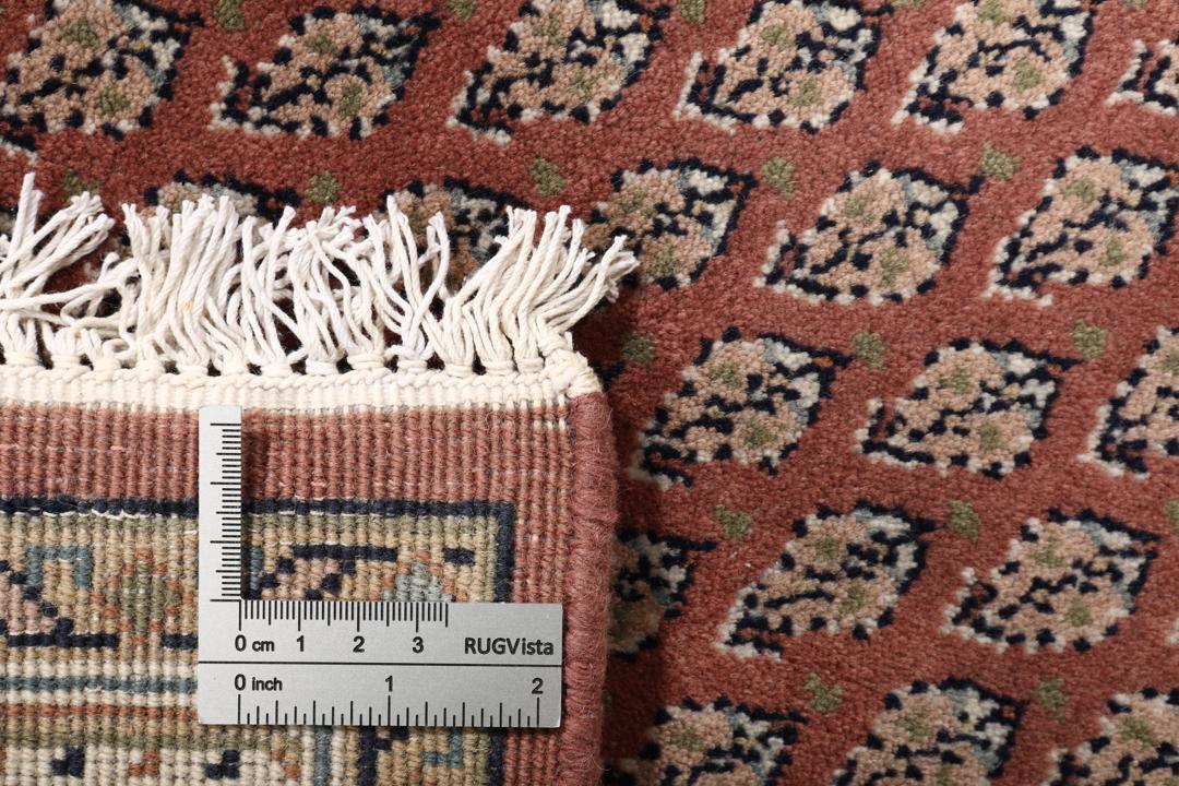 Een handgeknoopt Mir Indo tapijt uit India in donkerrood met een herhalend geometrisch patroon.