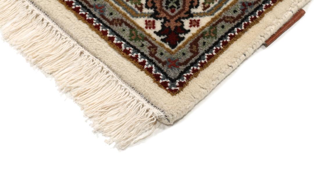Een handgeknoopt Tabriz tapijt uit India met een centraal medaillon in bruine en beige tinten.