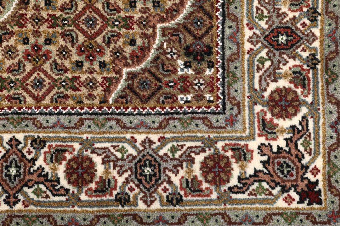 Een handgeknoopt Tabriz tapijt uit India met een centraal medaillon in bruine en beige tinten.