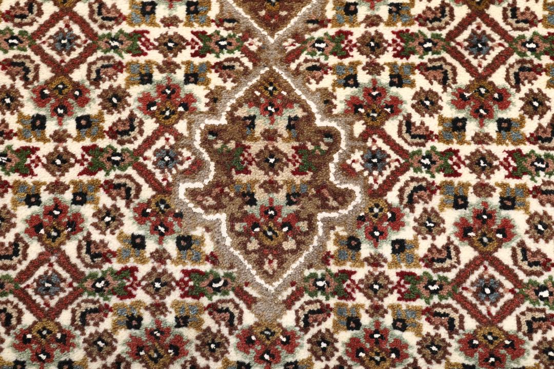 Een handgeknoopt Tabriz tapijt uit India met een centraal medaillon in bruine en beige tinten.