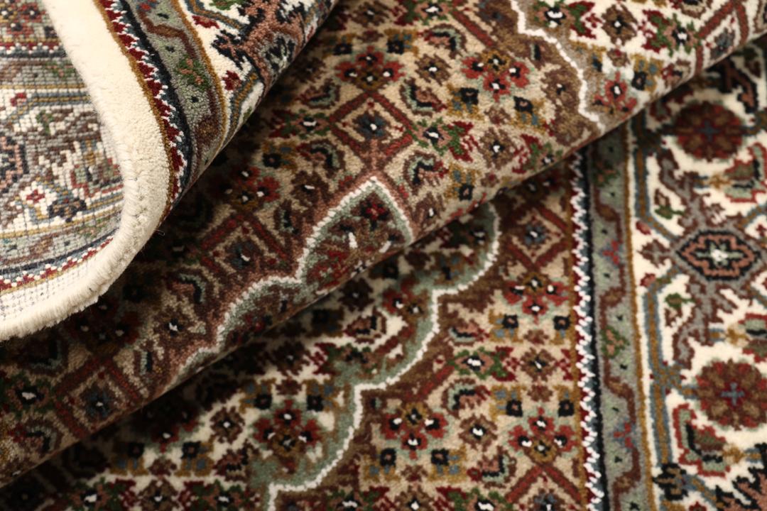 Een handgeknoopt Tabriz tapijt uit India met een centraal medaillon in bruine en beige tinten.