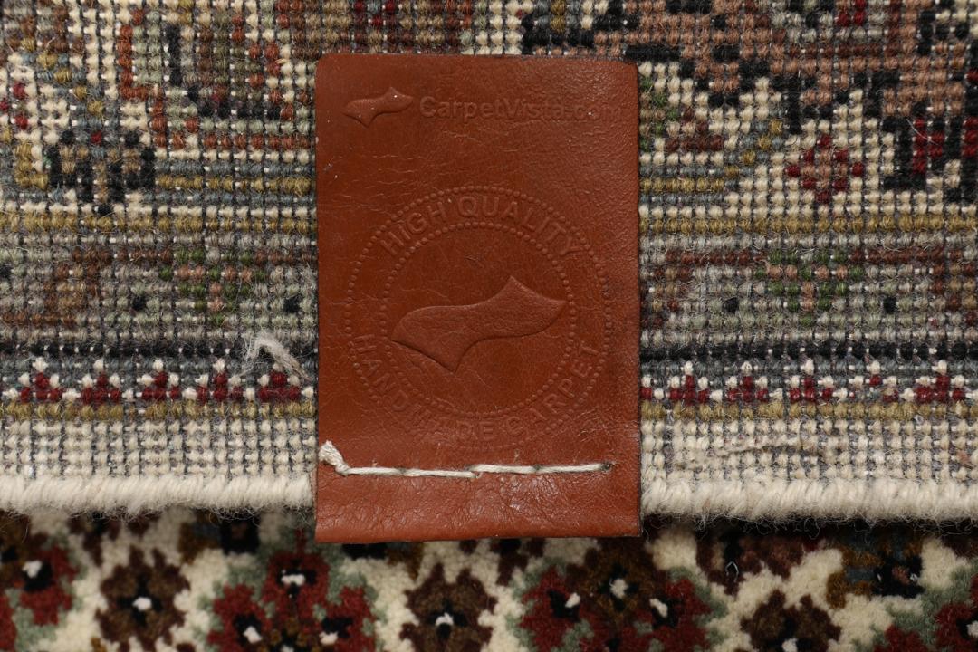 Een handgeknoopt Tabriz tapijt uit India met een centraal medaillon in bruine en beige tinten.
