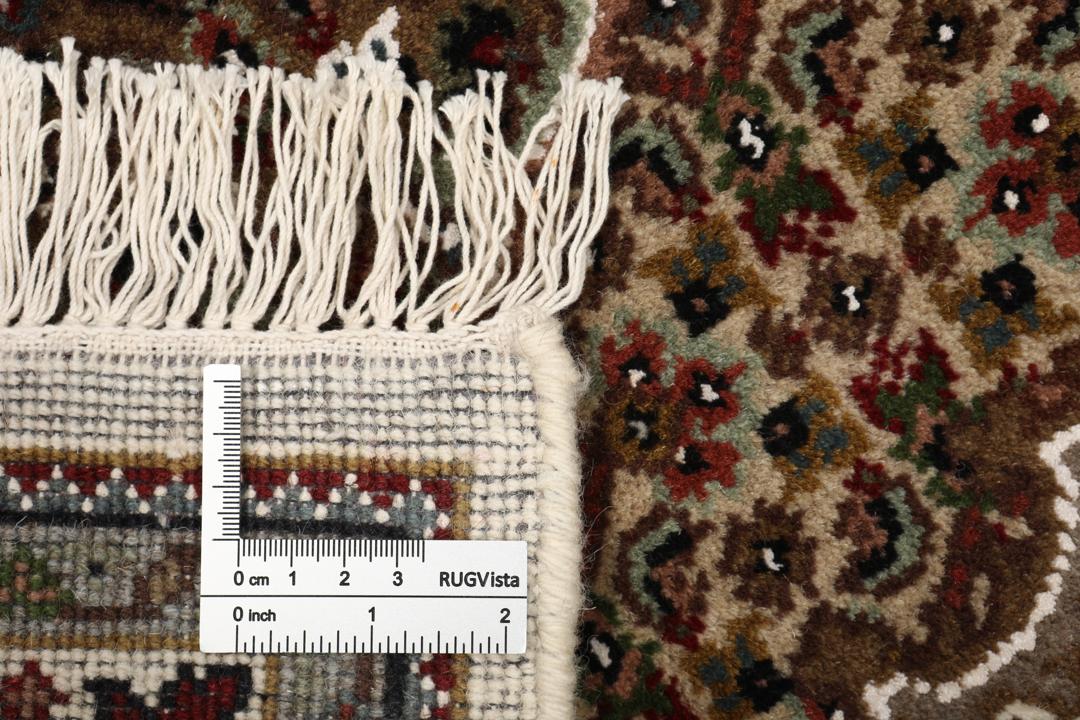 Een handgeknoopt Tabriz tapijt uit India met een centraal medaillon in bruine en beige tinten.