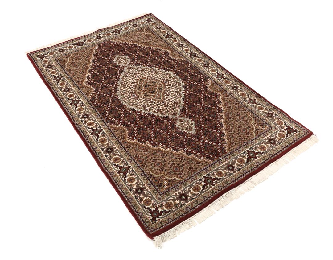 Een handgeknoopt Tabriz-tapijt uit India met een dieprood en beige medaillonpatroon