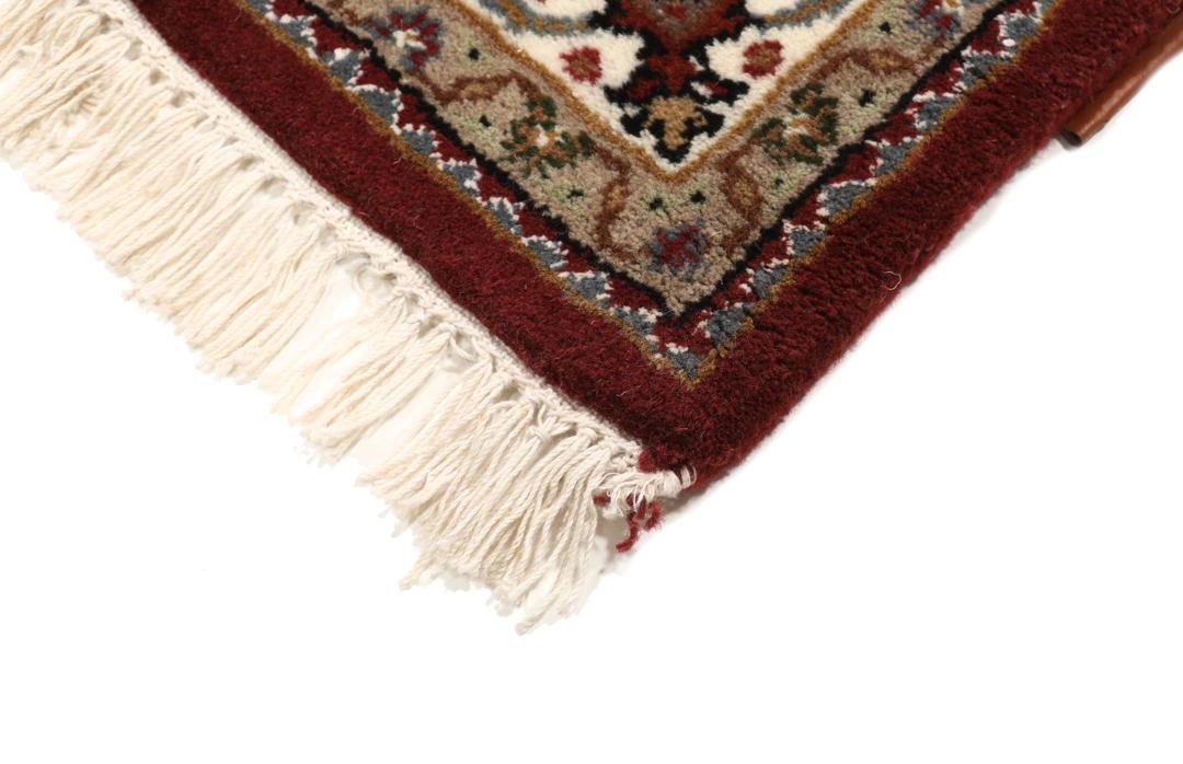 Een handgeknoopt Tabriz-tapijt uit India met een dieprood en beige medaillonpatroon