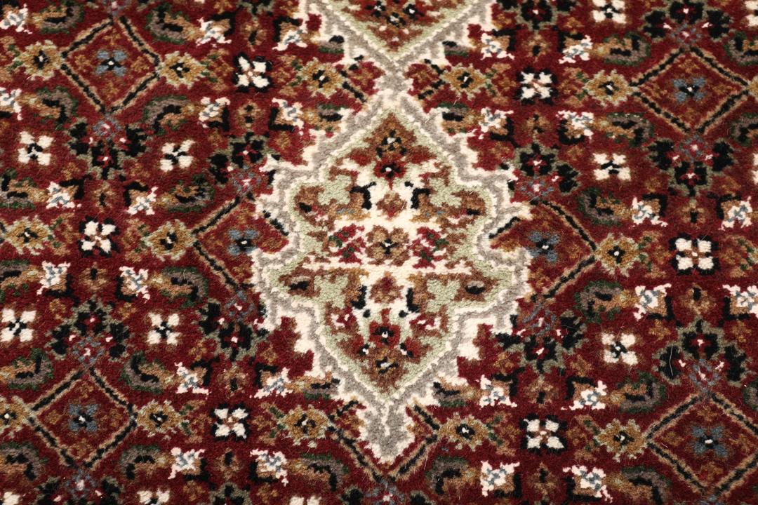 Een handgeknoopt Tabriz-tapijt uit India met een dieprood en beige medaillonpatroon