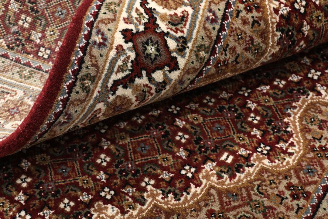 Een handgeknoopt Tabriz-tapijt uit India met een dieprood en beige medaillonpatroon