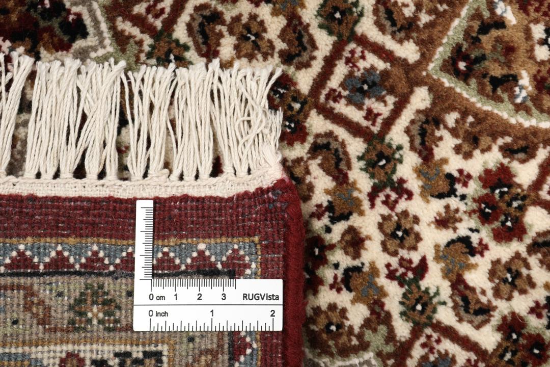 Een handgeknoopt Tabriz-tapijt uit India met een dieprood en beige medaillonpatroon