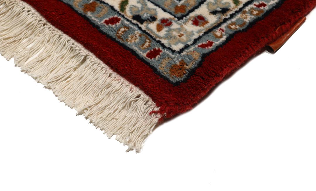 Et håndknyttet Nain Indo-tæppe fra Indien i mørkerøde og beige nuancer.