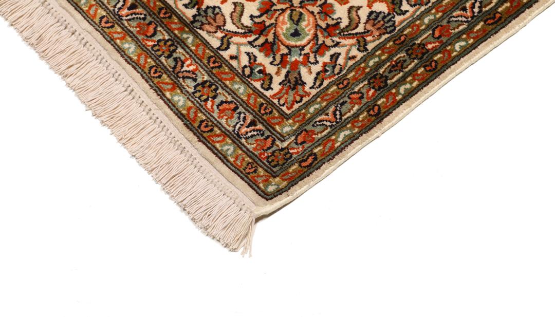 Et håndknyttet Kashmir-silketæppe fra Indien med en beige baggrund og indviklede blomstermotiver.