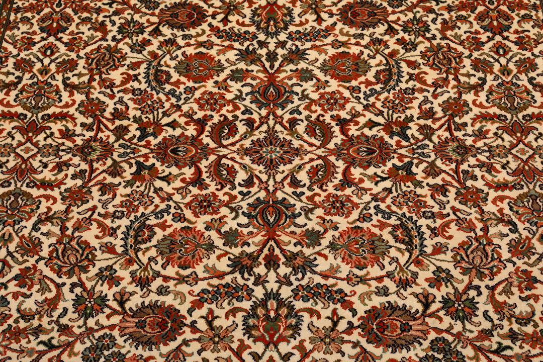 Et håndknyttet Kashmir-silketæppe fra Indien med en beige baggrund og indviklede blomstermotiver.