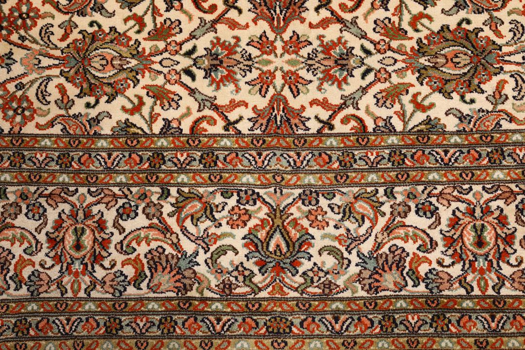Et håndknyttet Kashmir-silketæppe fra Indien med en beige baggrund og indviklede blomstermotiver.