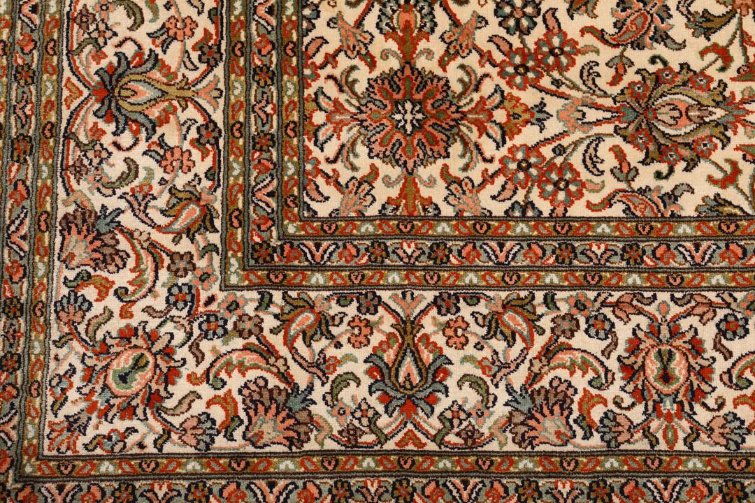 Et håndknyttet Kashmir-silketæppe fra Indien med en beige baggrund og indviklede blomstermotiver.
