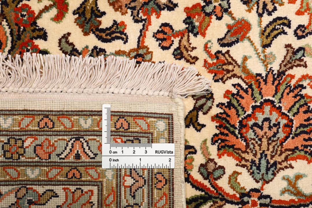 Et håndknyttet Kashmir-silketæppe fra Indien med en beige baggrund og indviklede blomstermotiver.
