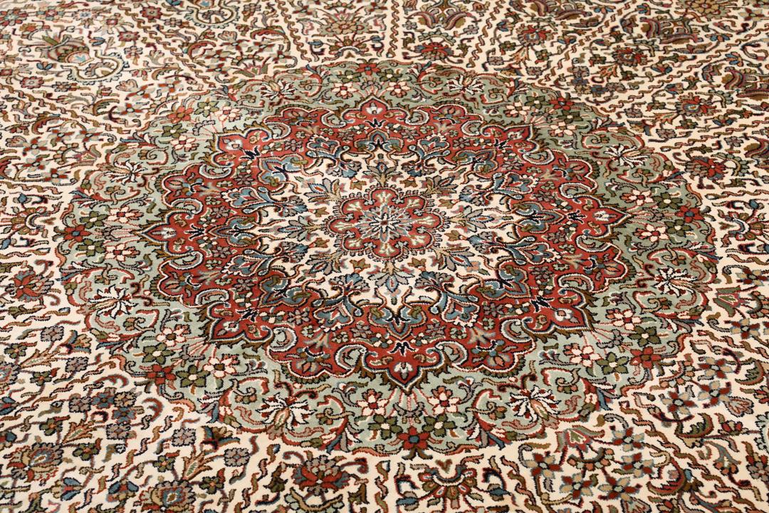 Et håndknyttet Kashmir-silketæppe fra Indien med et indviklet blomstermønster i beige og røde nuancer.