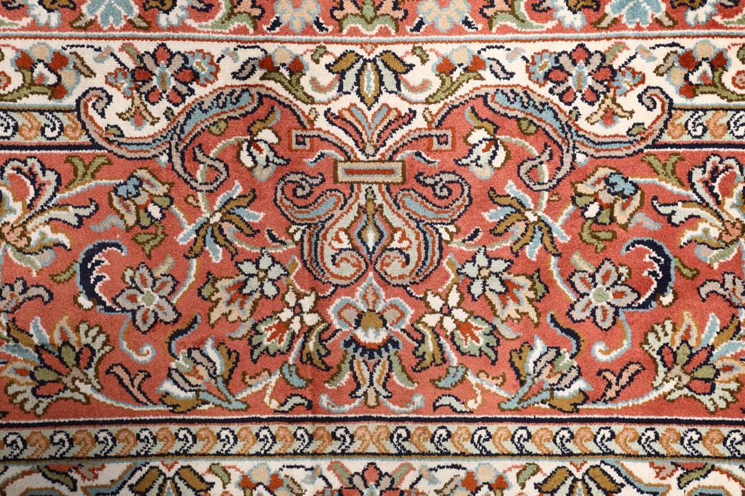 Et håndknyttet Kashmir-silketæppe fra Indien med et indviklet blomstermønster i beige og røde nuancer.