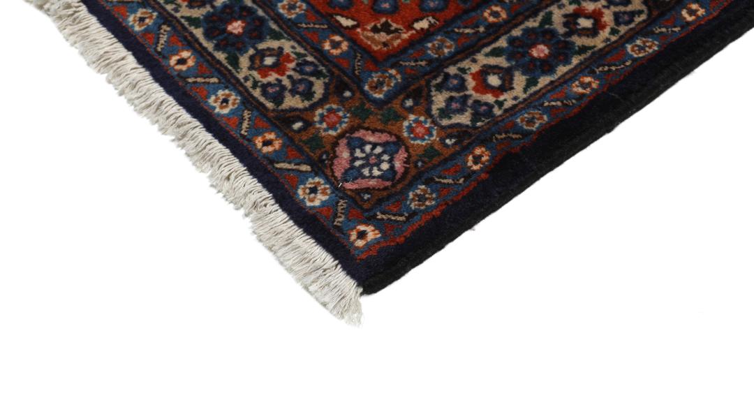 A large rectangular Moud rug from the Middle East featuring a dark-red and beige floral medallion design.