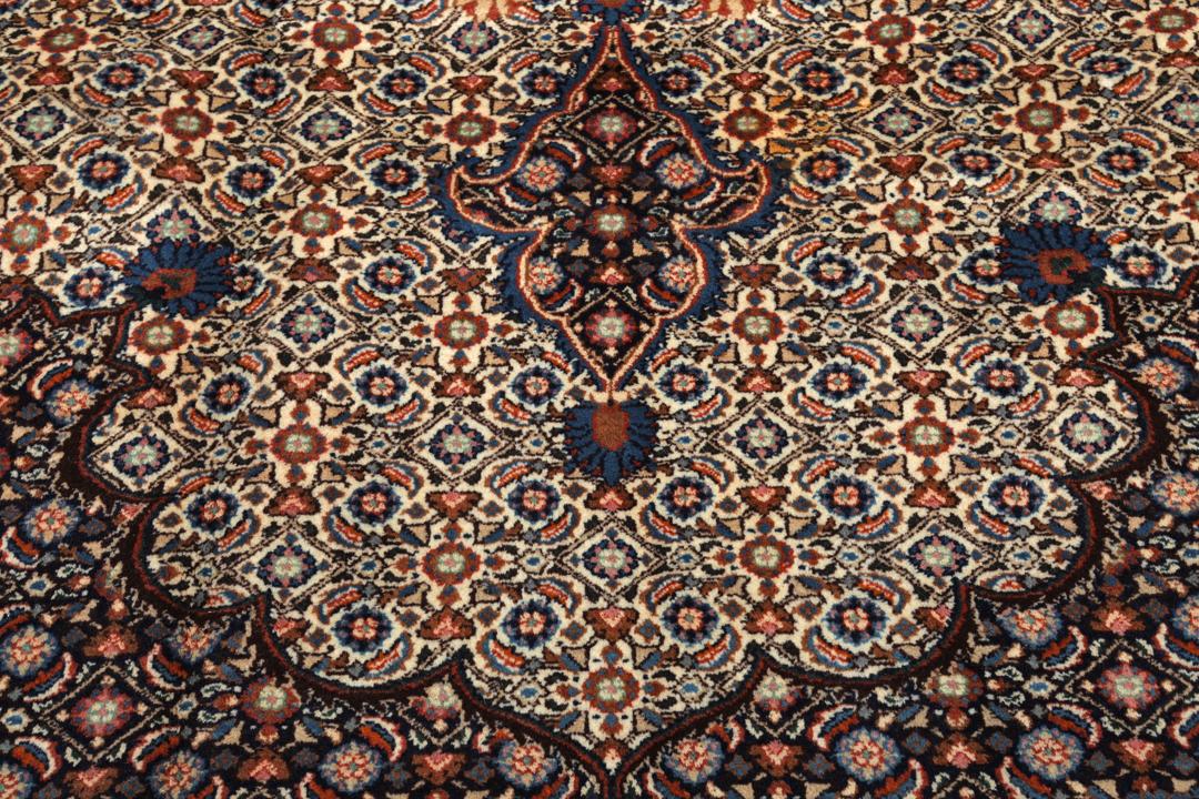A large rectangular Moud rug from the Middle East featuring a dark-red and beige floral medallion design.
