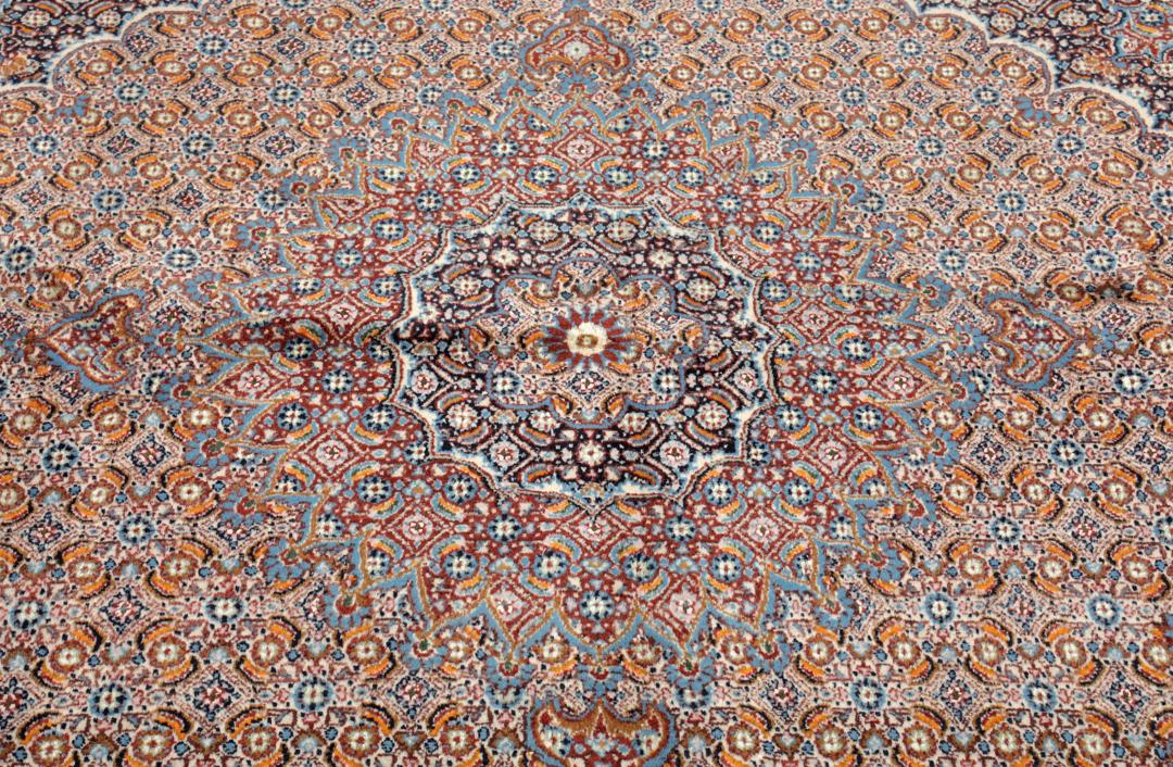 Hand-knotted Moud rug with a central medallion and ornate floral patterns in dark-red and blue