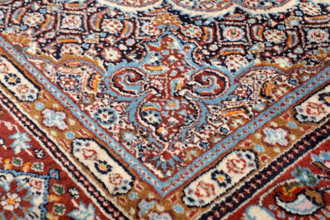 Hand-knotted Moud rug with a central medallion and ornate floral patterns in dark-red and blue