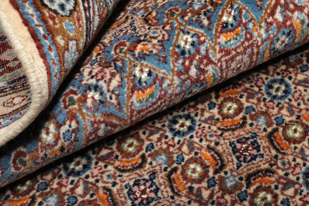 Hand-knotted Moud rug with a central medallion and ornate floral patterns in dark-red and blue