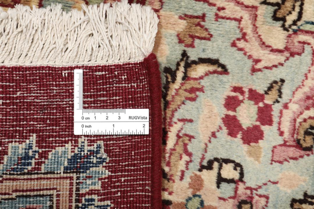 Hand-knotted Mashad rug from the Middle East featuring a dark-red field with intricate floral patterns.