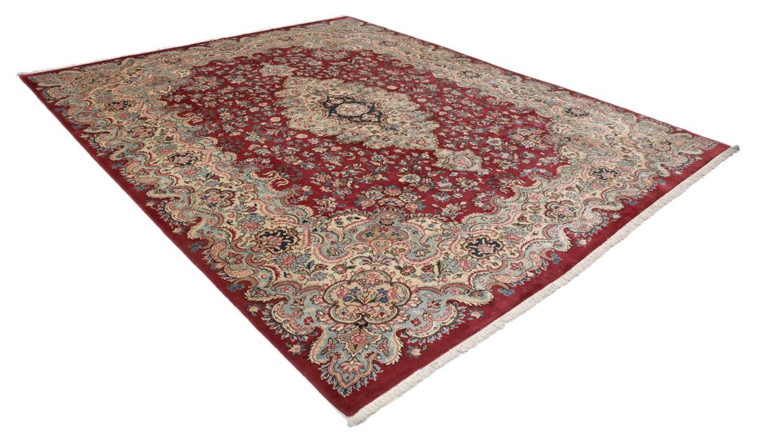 Hand-knotted Mashad rug from the Middle East featuring a dark-red field with intricate floral patterns.