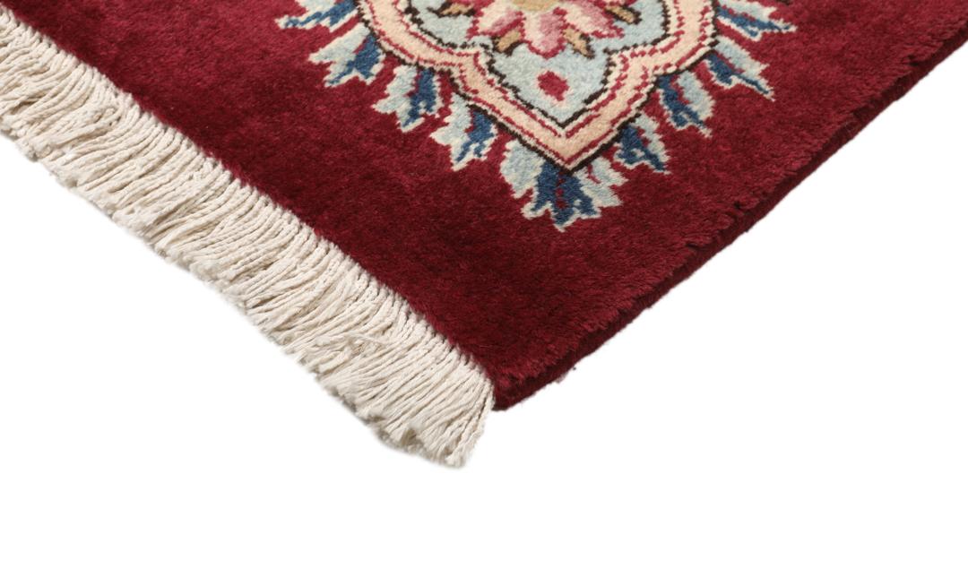 Hand-knotted Mashad rug from the Middle East featuring a dark-red field with intricate floral patterns.