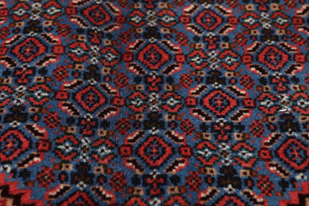 Hand-knotted Senneh rug from the Middle East in dark-red and blue tones