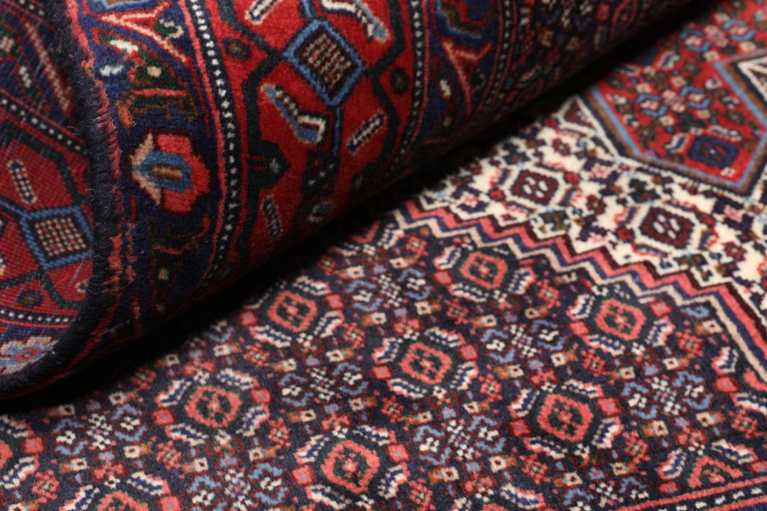 Hand-knotted Senneh rug from the Middle East in dark-red and blue tones