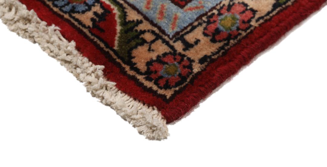 A hand-knotted Senneh rug from the Middle East featuring a dark-red field with geometric motifs.