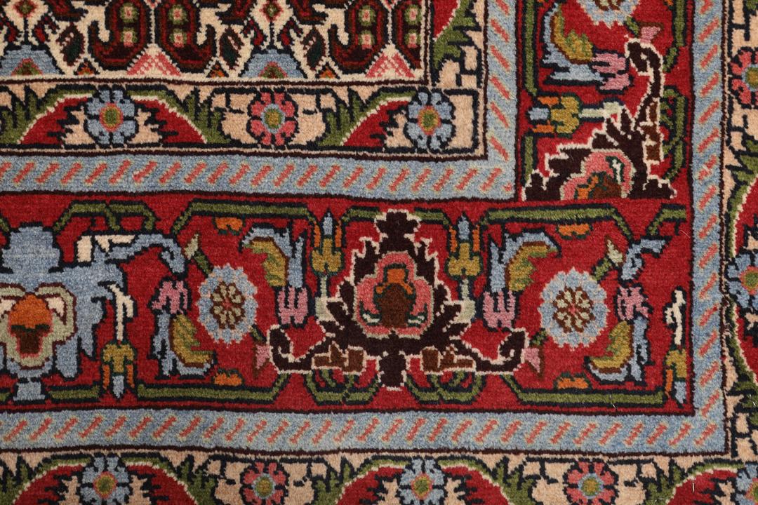 A hand-knotted Senneh rug from the Middle East featuring a dark-red field with geometric motifs.